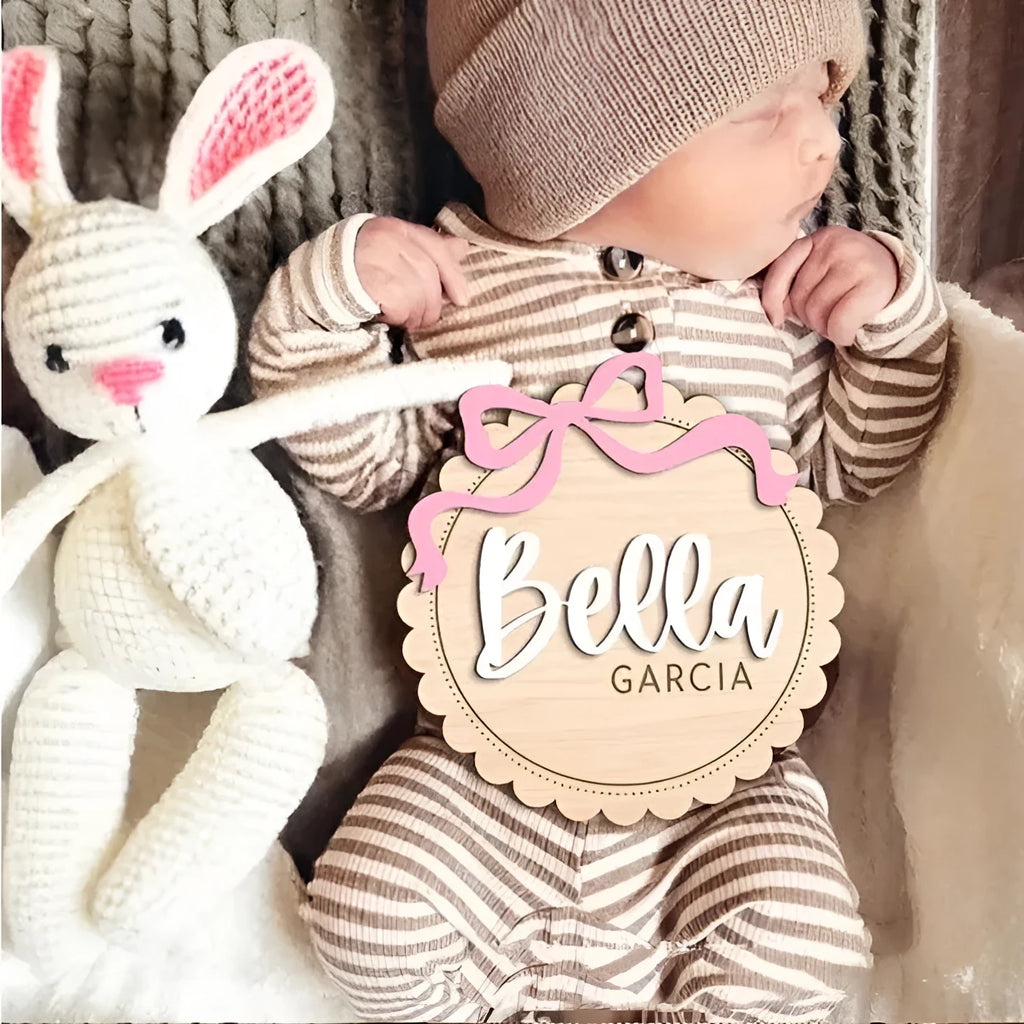 Customisable square wooden baby room ornament with a name, shown in two size options.