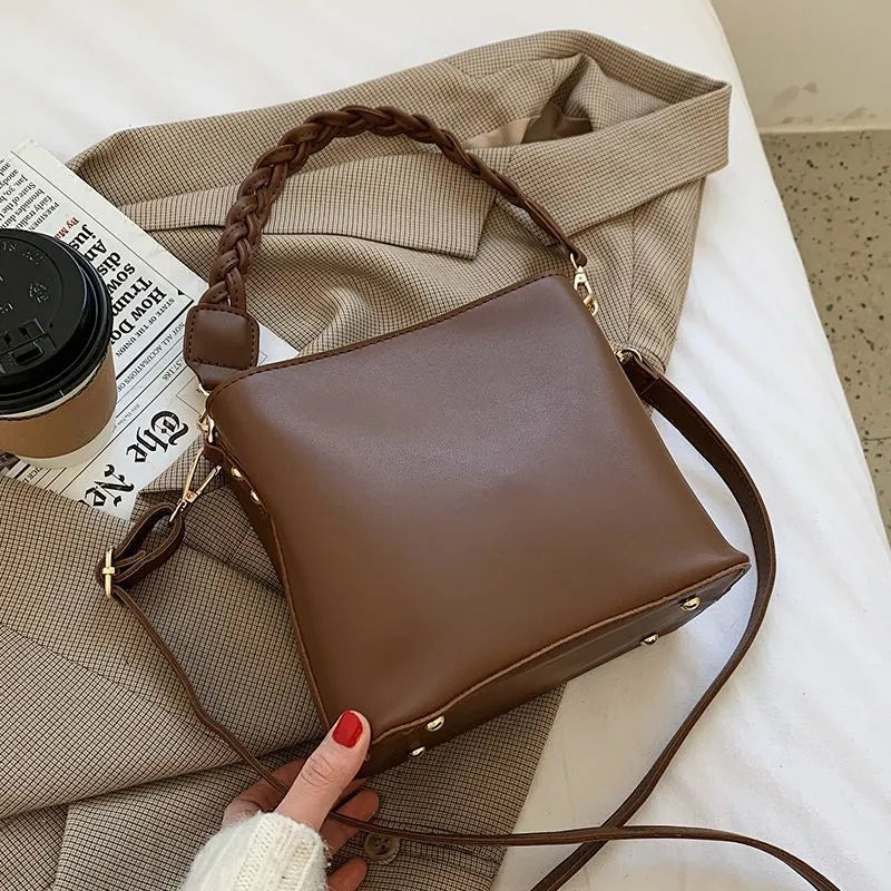 Retro woven PU bucket bag in khaki colour with crossbody strap shown in model shot