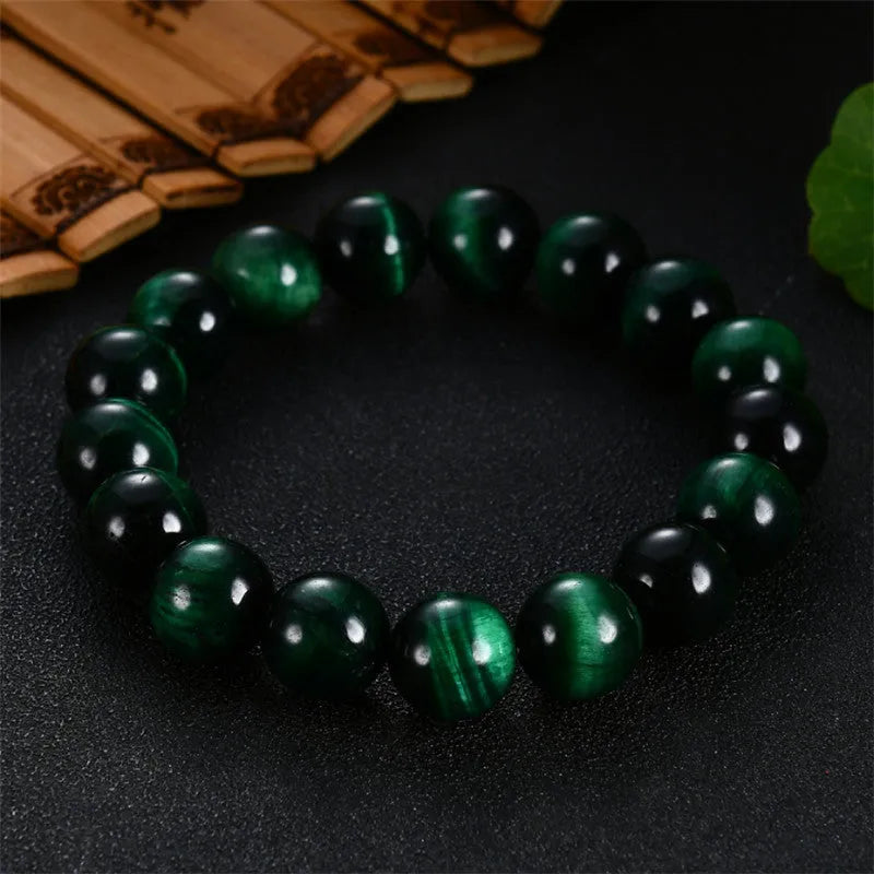 Polished green tiger eye stone beaded bracelet on a white background, showing geometric shaped beads.