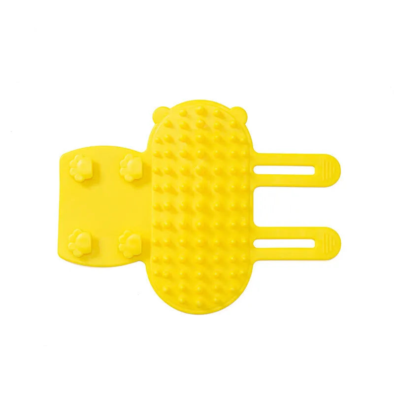 Silicone cat grooming comb with adjustable strap attached to furniture leg for scratching and hair removal