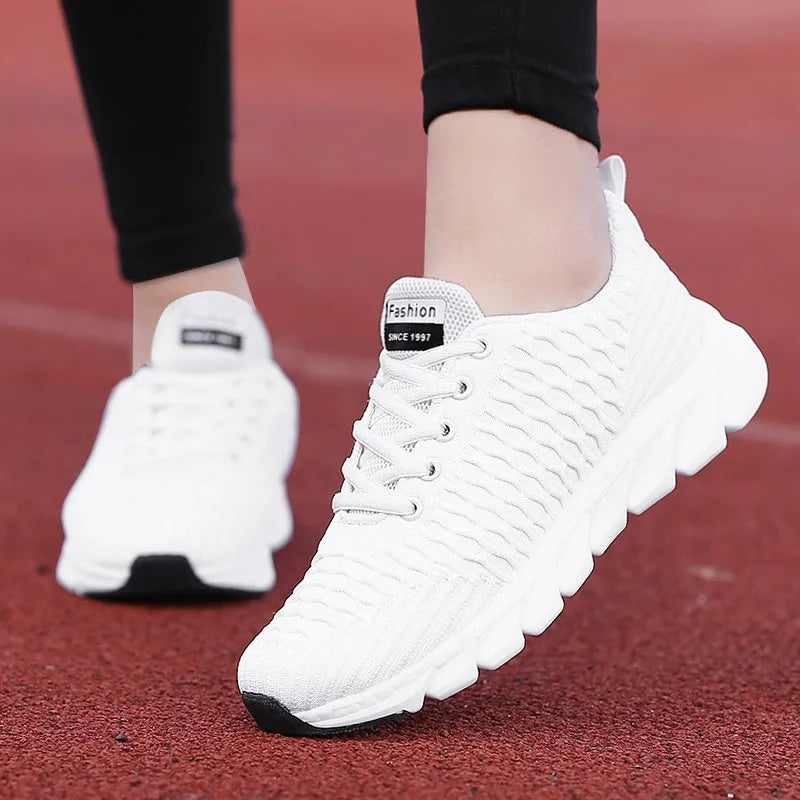 Women's running shoes in black, pink and white colours showing flyweave upper texture
