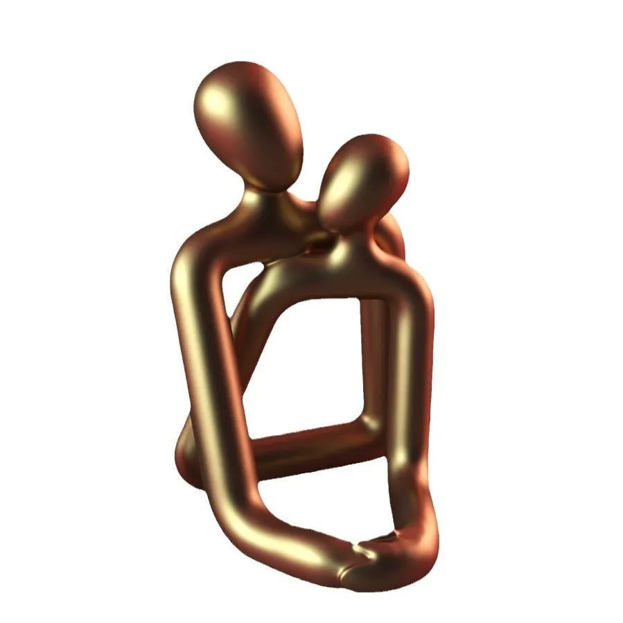Modern loving couple resin statue in milky white or gold on a bookshelf.