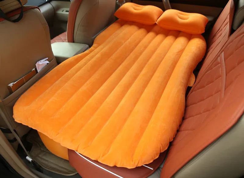 Black inflatable car bed with flocked surface, two pillows, and storage bag for five-seater vehicles