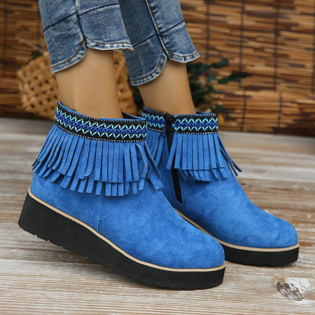 Women's suede ankle boot with wedge rubber sole, side zip, and tassel detail in dark brown.