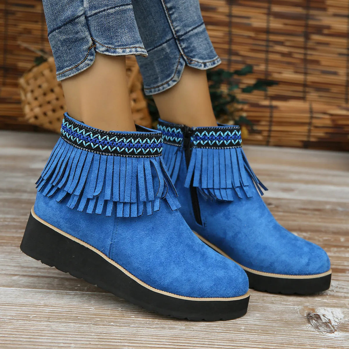 Women's suede ankle boot with wedge rubber sole, side zip, and tassel detail in dark brown.
