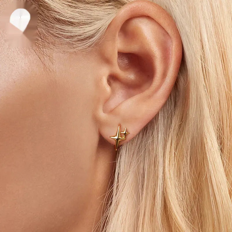 Close-up of a pair of oxidised sterling silver clip-on earrings featuring a minimalist star motif.