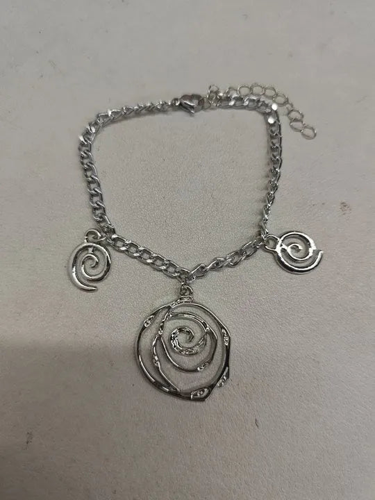 Gold spiral donut necklace, bracelet, and earrings set for women on a grey background.