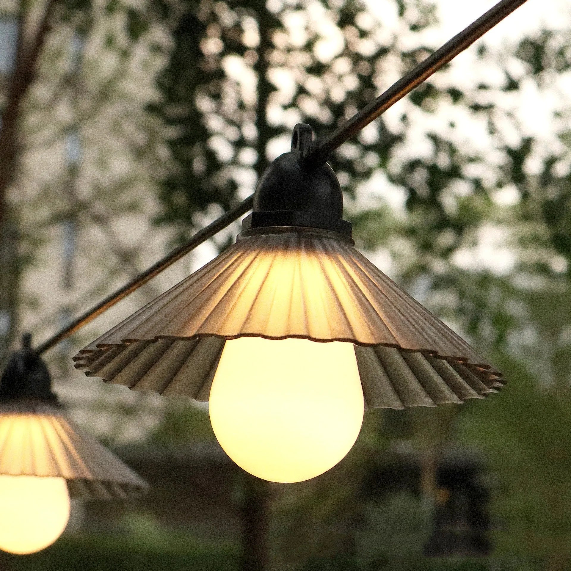 Outdoor LED string lights with flower-shaped coloured globes for garden patio decoration