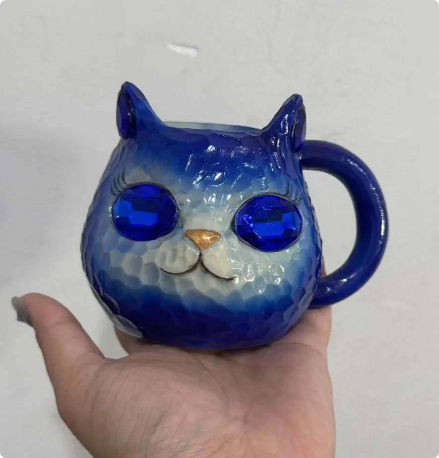 Purple, green, blue, and pink resin cat cup crystal earth craft ornament on display.