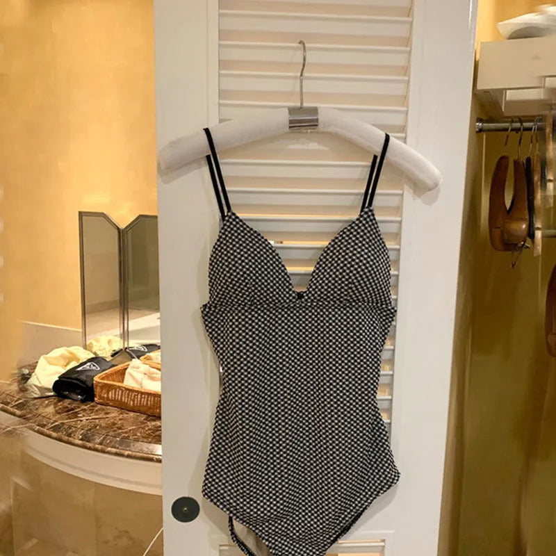 Blue one-piece swimsuit on a model, showing its cover belly design for a slim figure.