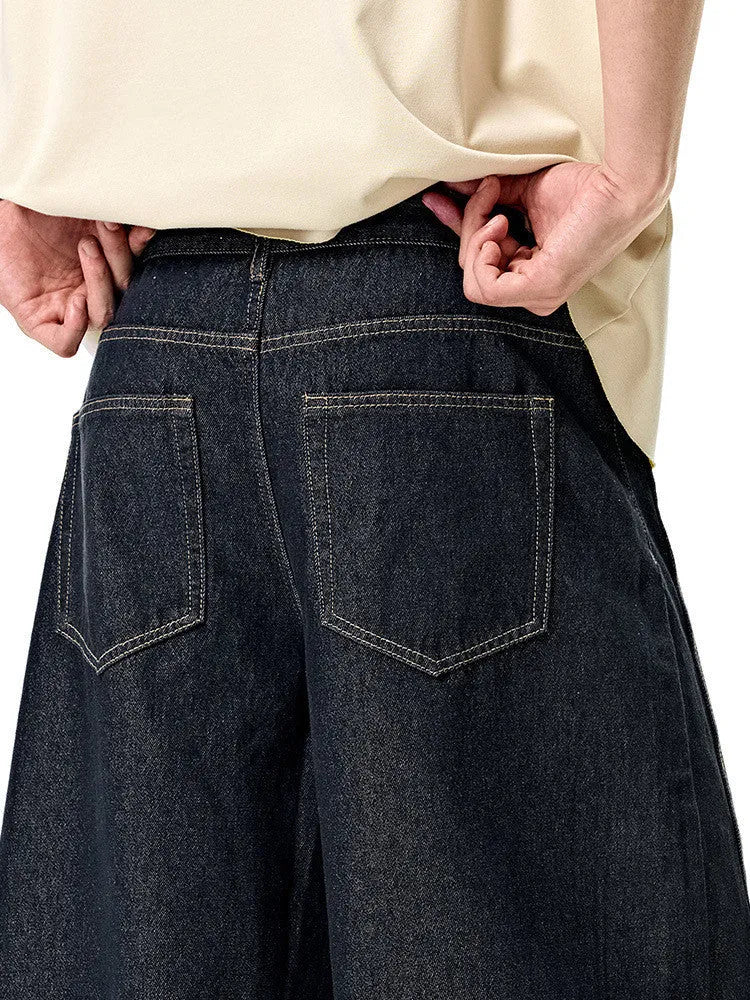 Men's wide leg denim trousers in original cow colour on a hanger, showing the relaxed fit and mid waist design.