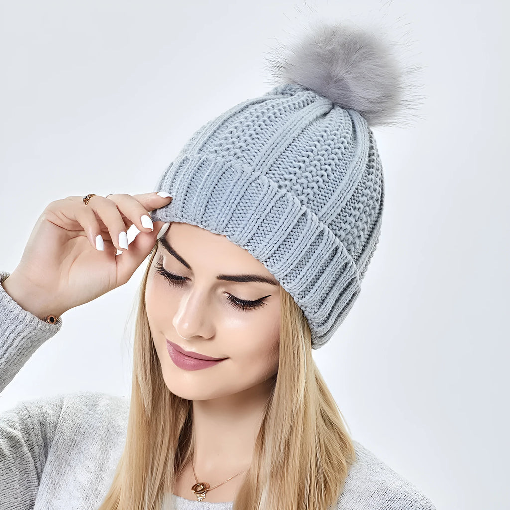 Women's knit beanie hat with faux fur pom pom and satin lining in various colours.