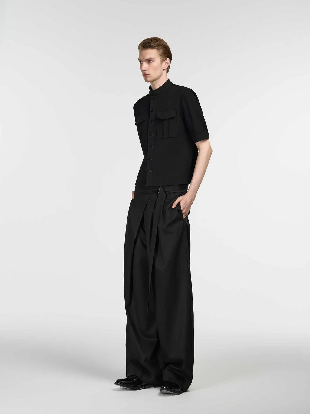 Black straight-leg trousers made from Tencel and cotton blend with a single pleat and adjustable waistband.