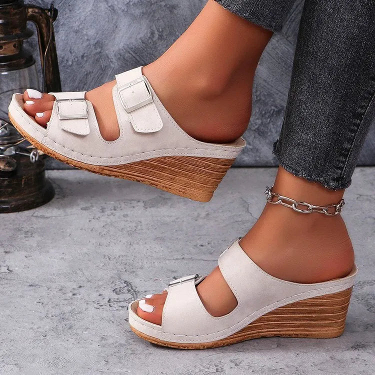 Women's creamy-white wedge buckle slippers with PU upper and rubber sole on a plain background.