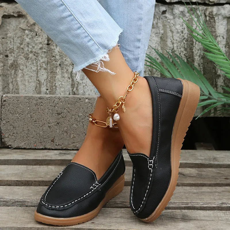 Women's flat loafer in PU leather with car suture stitching and a round toe.
