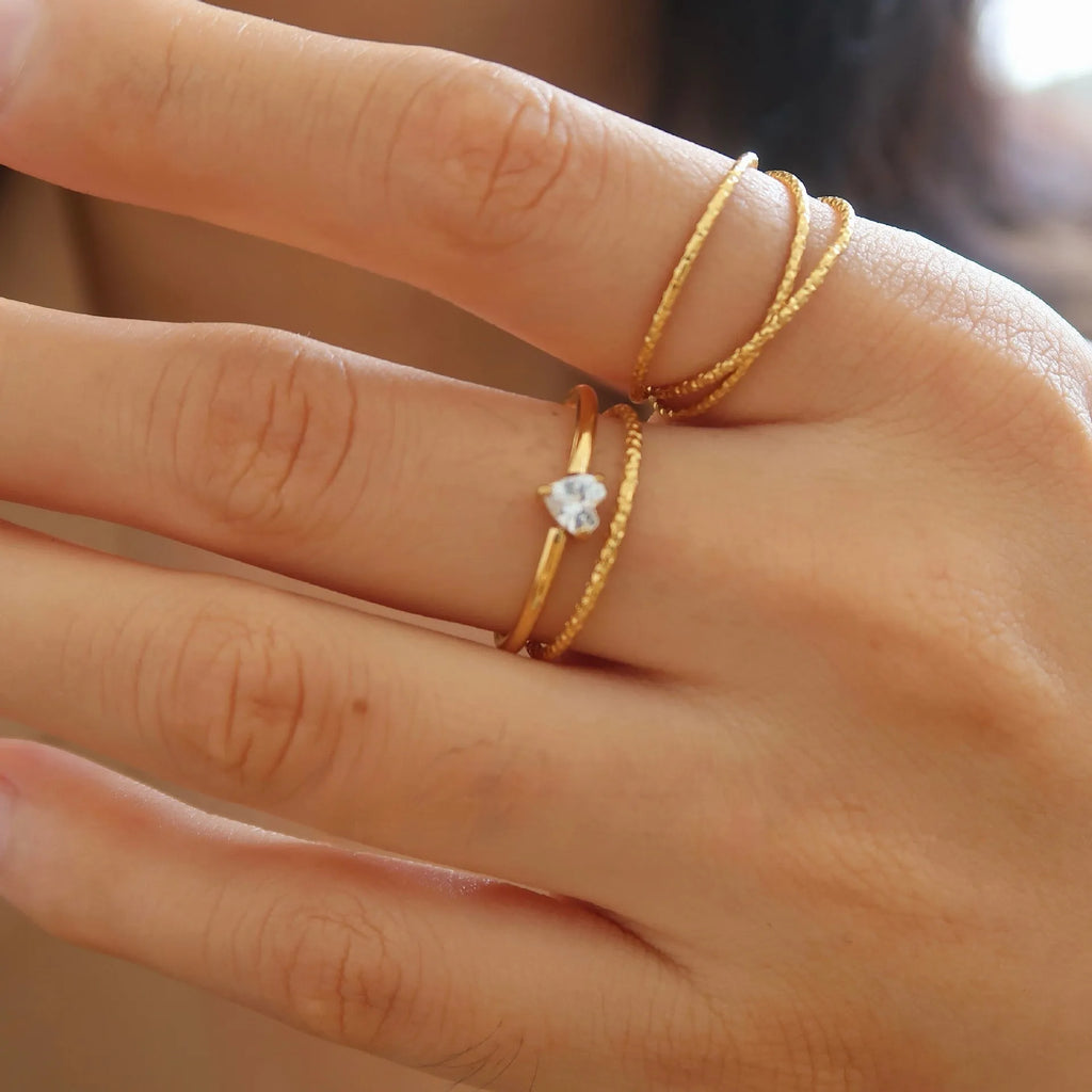 Gold electroplated stainless steel women's ring with heart design in oval shape on finger