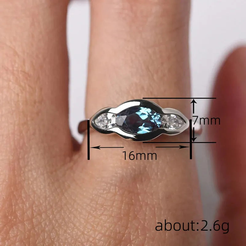 Geometric ellipse-shaped women's ring in white gold colour with inlaid zircon stones.