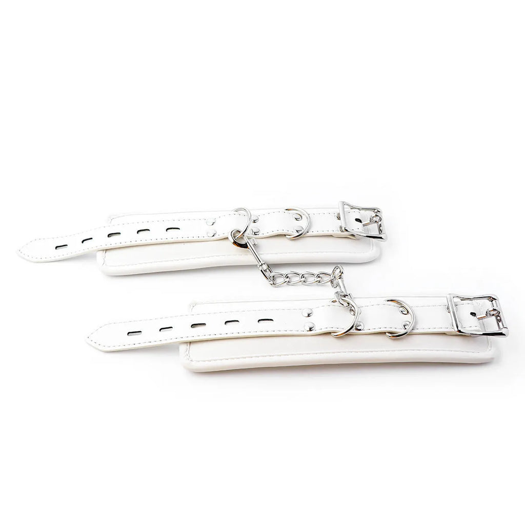 White PU sponge bondage restraint set showing handcuffs, foot cuffs, and a neck cuff on a neutral background.