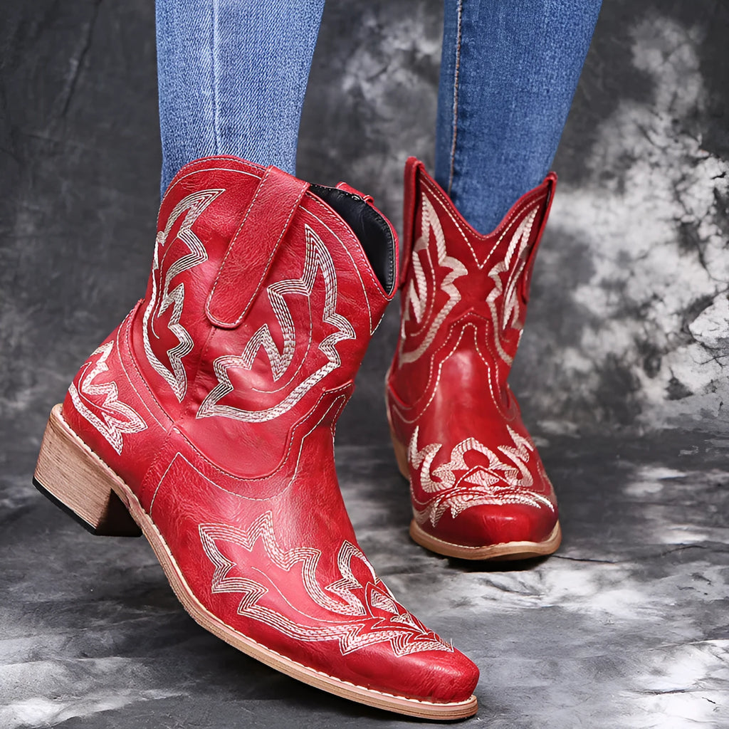 Blue women's cowboy boots with embroidered detail, a low wedge heel, and a pointed toe.