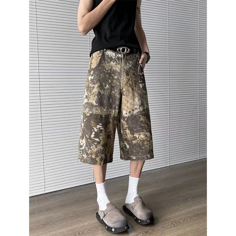 Yellow snake camouflage pattern on cropped denim jeans laid flat.