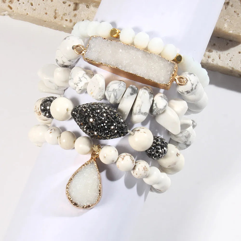 Set of five handmade stretch bracelets with glass, crystal, and hematite beads in irregular shapes on a neutral background
