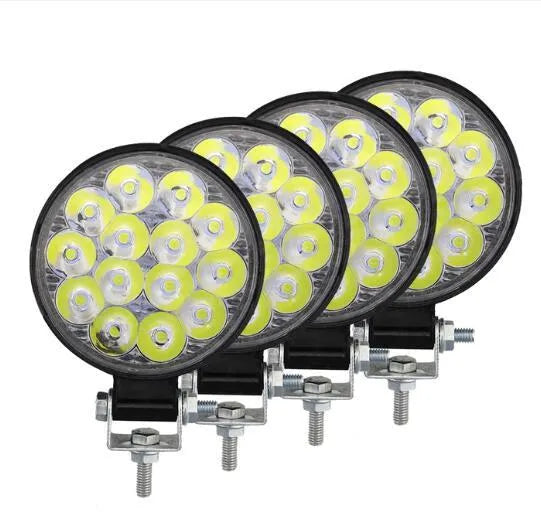 White mini round LED work light with aluminium housing, mounted as an auxiliary car or truck light.