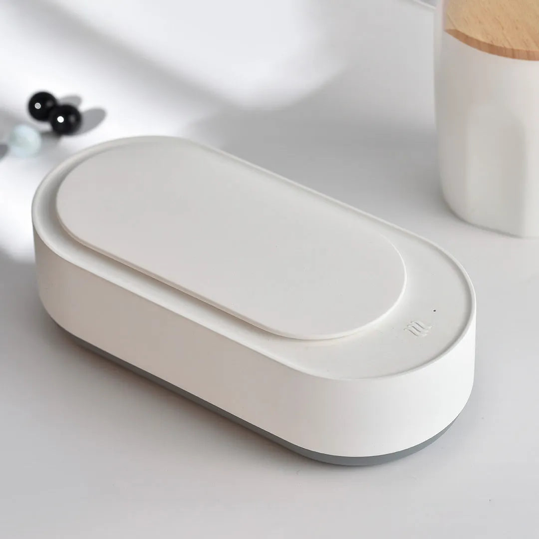 White portable ultrasonic cleaner with digital display and stainless steel cleaning tank.