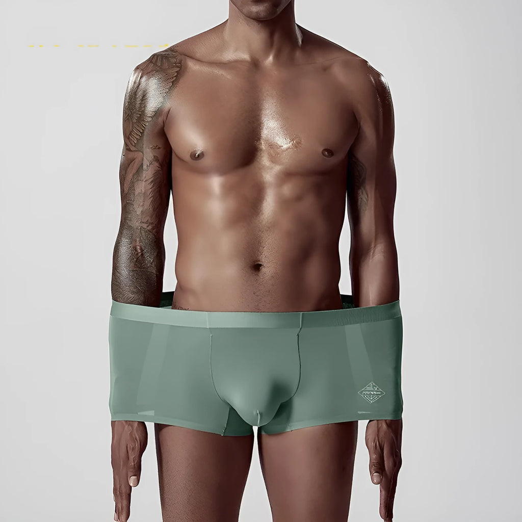 Men's seamless one-piece modal underwear in green, shown flat, highlighting its mid-waist and solid colour design.