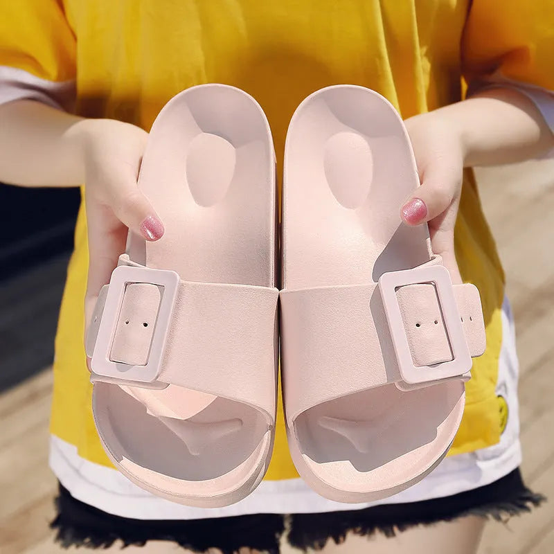 Women's grey blue EVA buckle slippers on a light background.