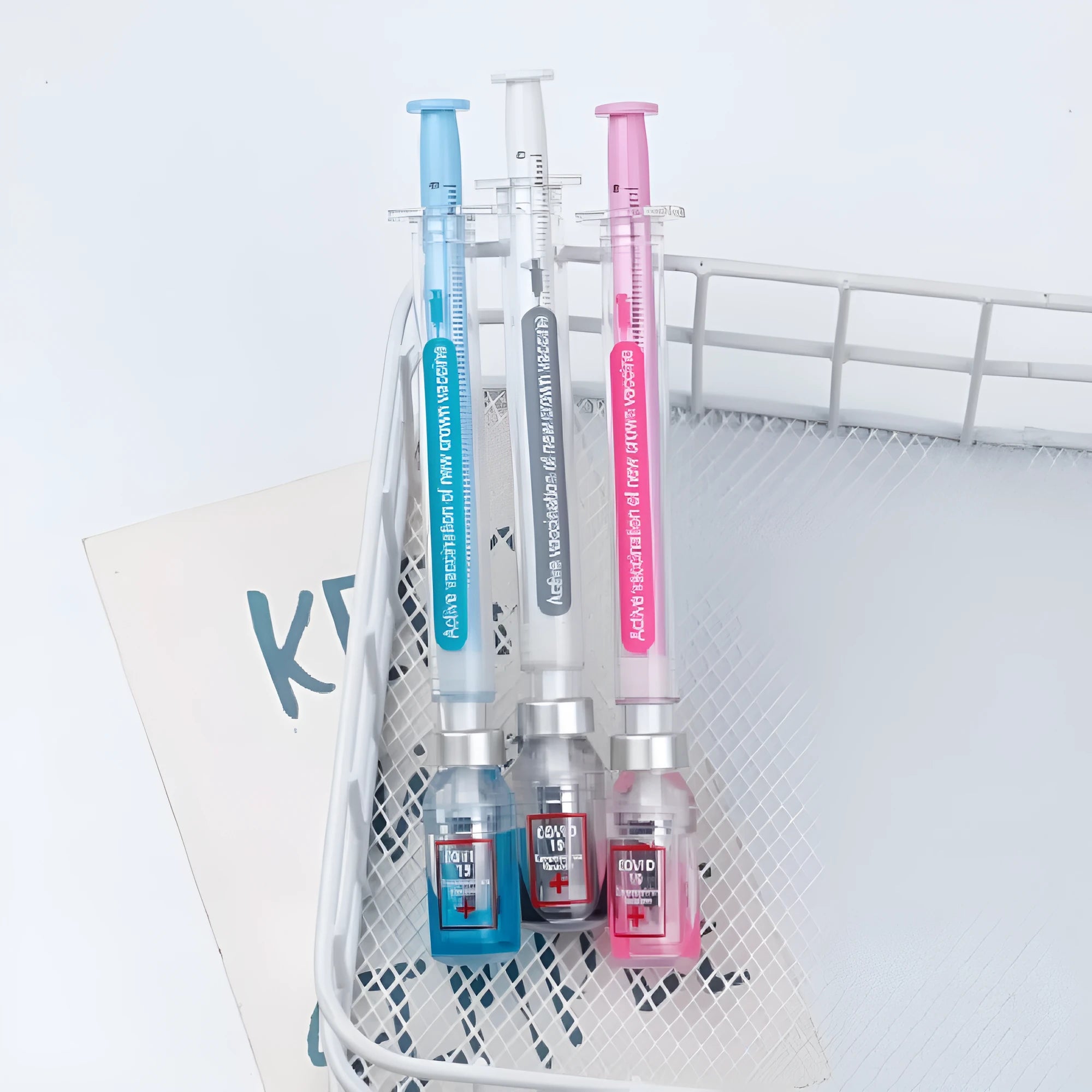 White and blue vaccine pen design gel pen with cap, shown next to a black full needle tube refill.
