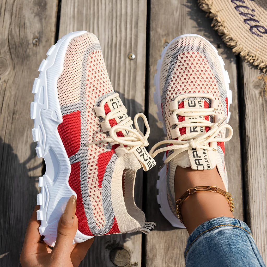 Women's Flyknit mesh lace-up sneakers in a grey colourway showing round toe and low profile.
