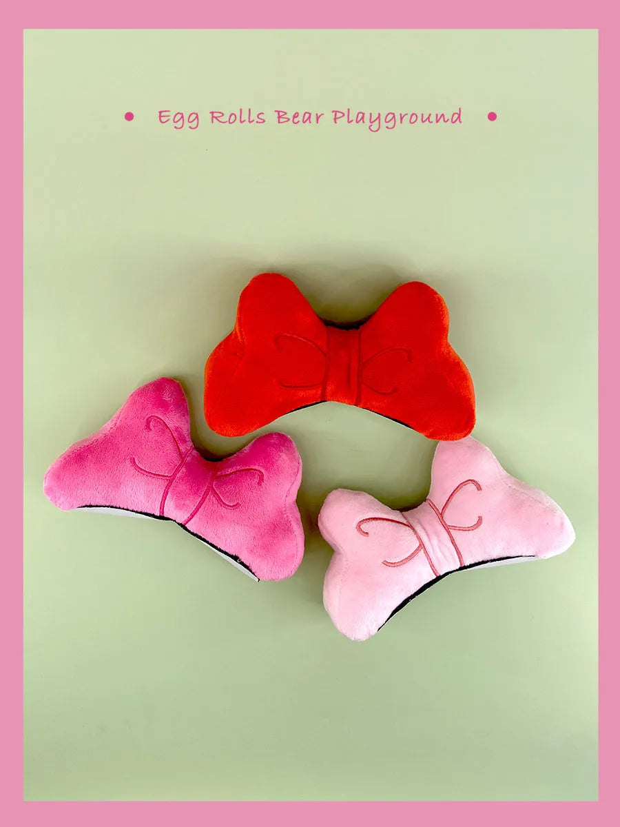 Soft plush bow tie decoration for motorcycle and ski helmets in red or pink colours.