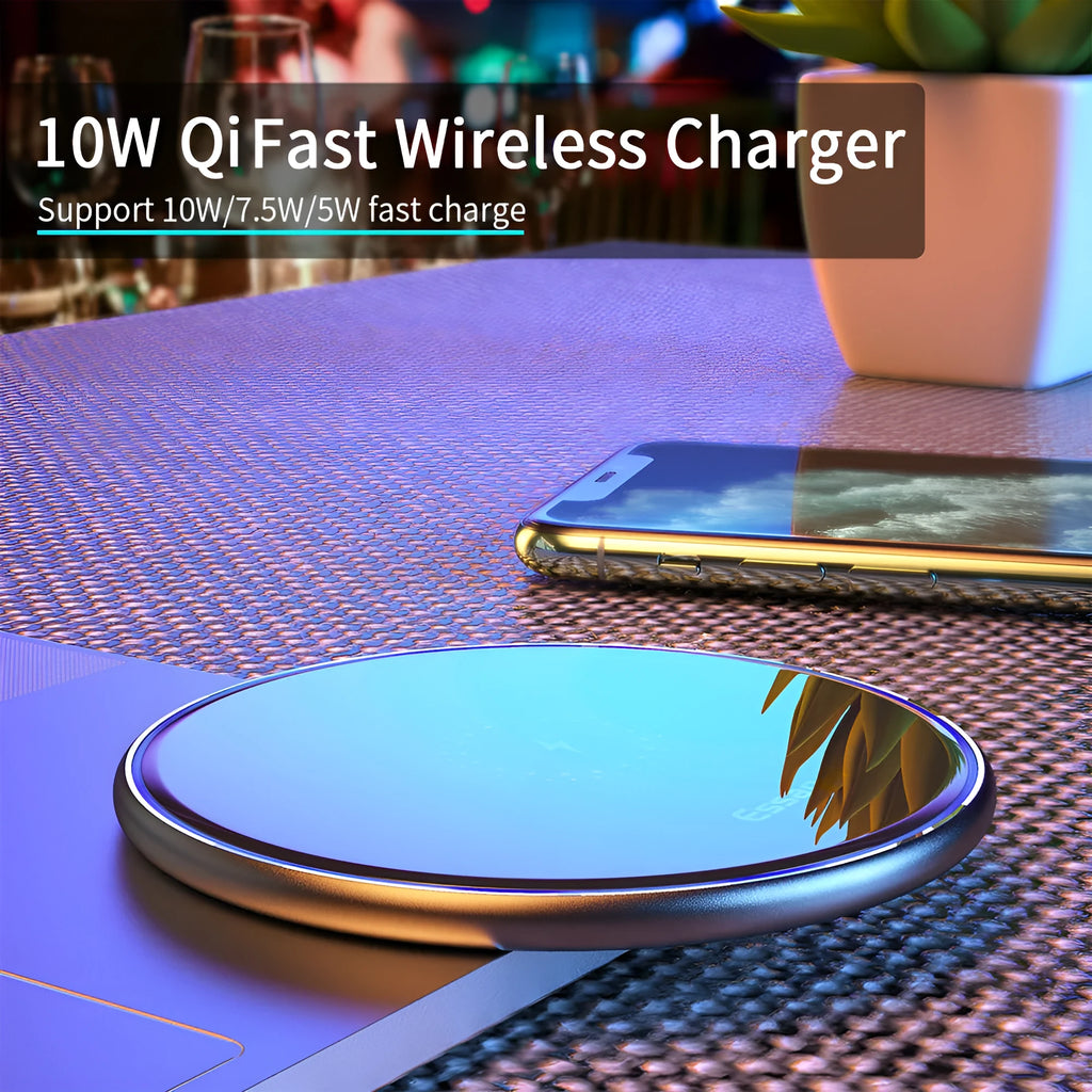 Black wireless charging pad on desk with phone charging, showing blue LED indicator light