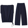 Women's linen blend co-ord set showing flounced sleeve off-neck top with wide leg trousers in temperament commute style