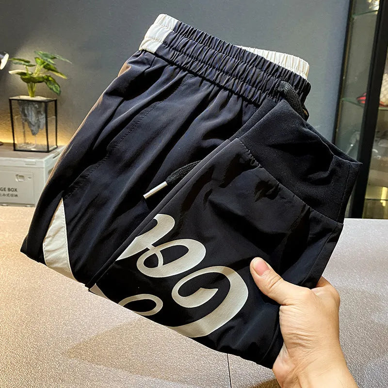 Men's solid black ultra-thin ice silk cotton trousers with a cropped leg and elasticated ankle band.