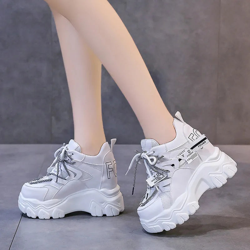 Women's white breathable mesh platform sports shoe with a cross strap on a rubber sole