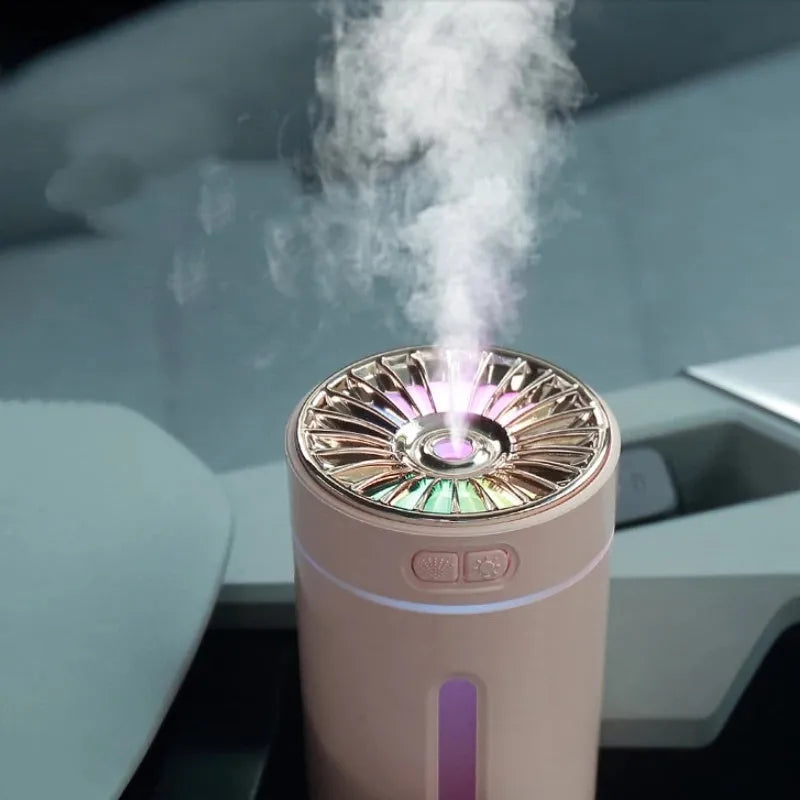 Compact black wireless humidifier with colourful LED lights sitting in car cup holder