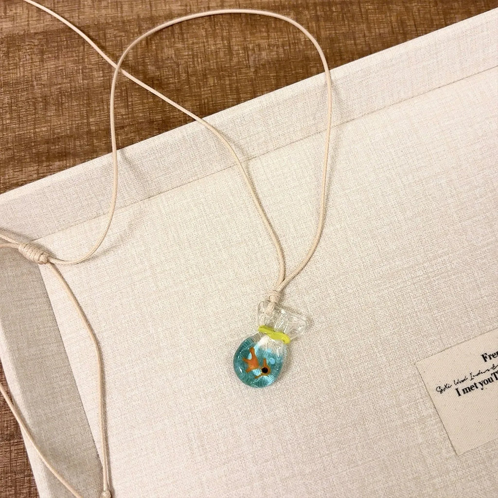 Women's joker pendant necklace with coloured glaze ornament on a cotton and linen clavicle chain.