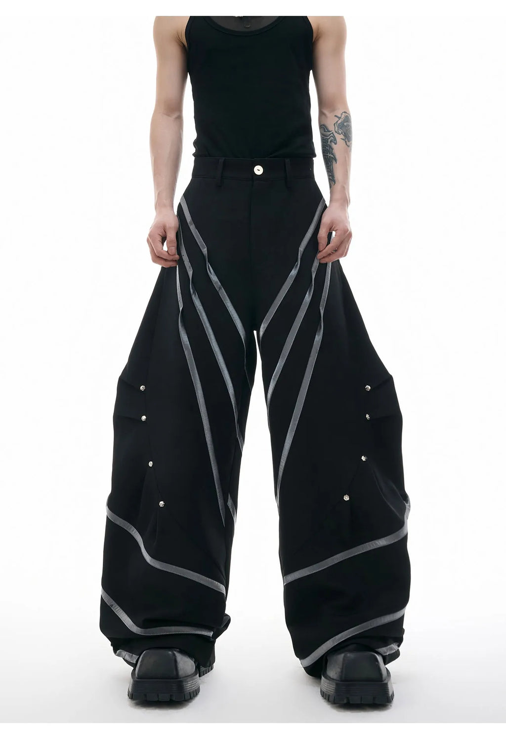 Men's black trousers with three-dimensional cutting and metal rivet pleats on a white background.