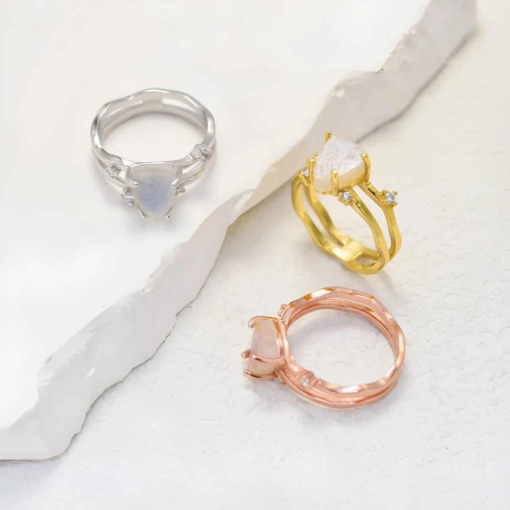 S925 silver ring with an irregular triangle shape holding a moonstone, shown in a rose gold electroplated finish.