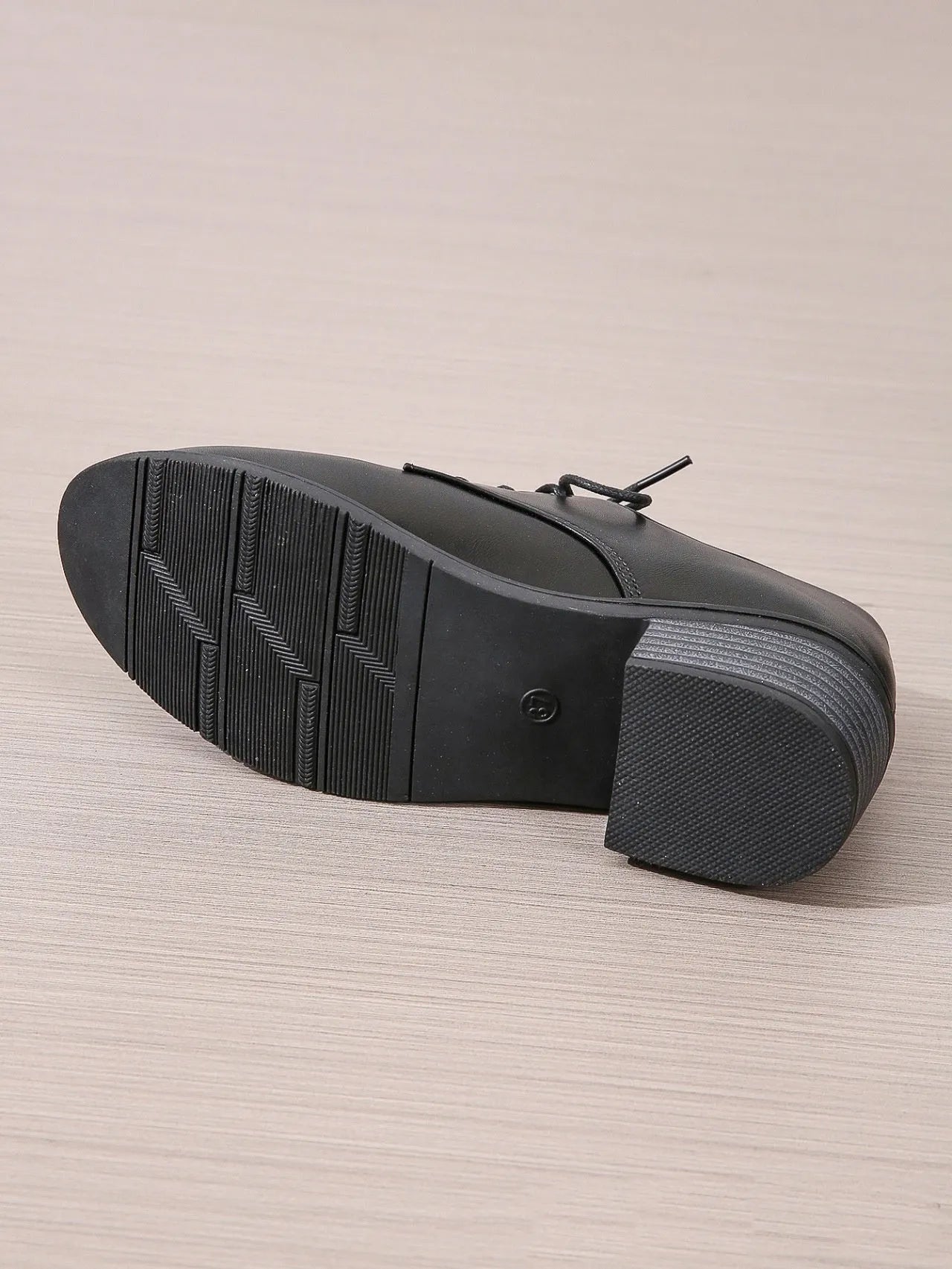 Black women's low-top work shoes with a thick chunky mid-heel and rubber sole.