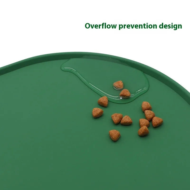 Green silicone placemat for cat bowls on a wooden floor.