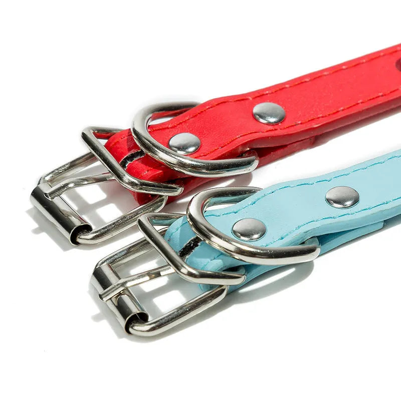 A studded dog collar made of black PU leather with a row of metal spikes and a silver metal buckle.