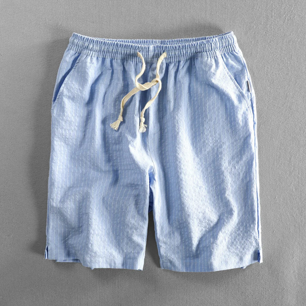 Man wearing loose fit striped cotton shorts in a casual setting.