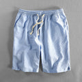 Man wearing loose fit striped cotton shorts in a casual setting.