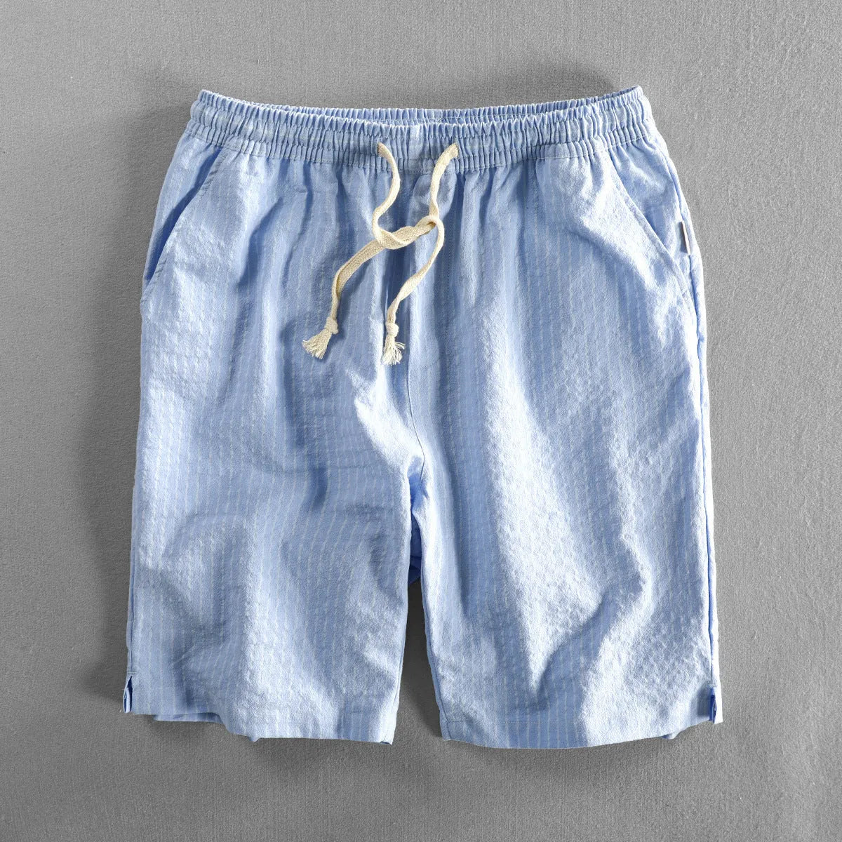 Man wearing loose fit striped cotton shorts in a casual setting.