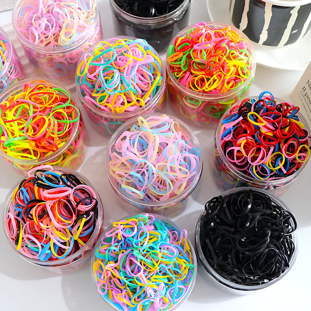 Multi-colour TPU baby hair ties in a reusable plastic storage container.