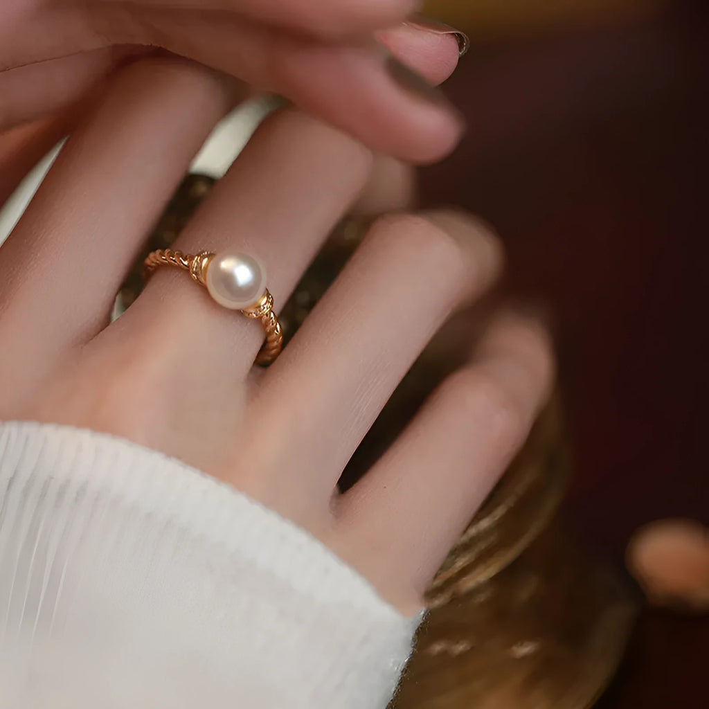 Adjustable antique-style copper ring with twisted geometric band and a pearl inlay centre.