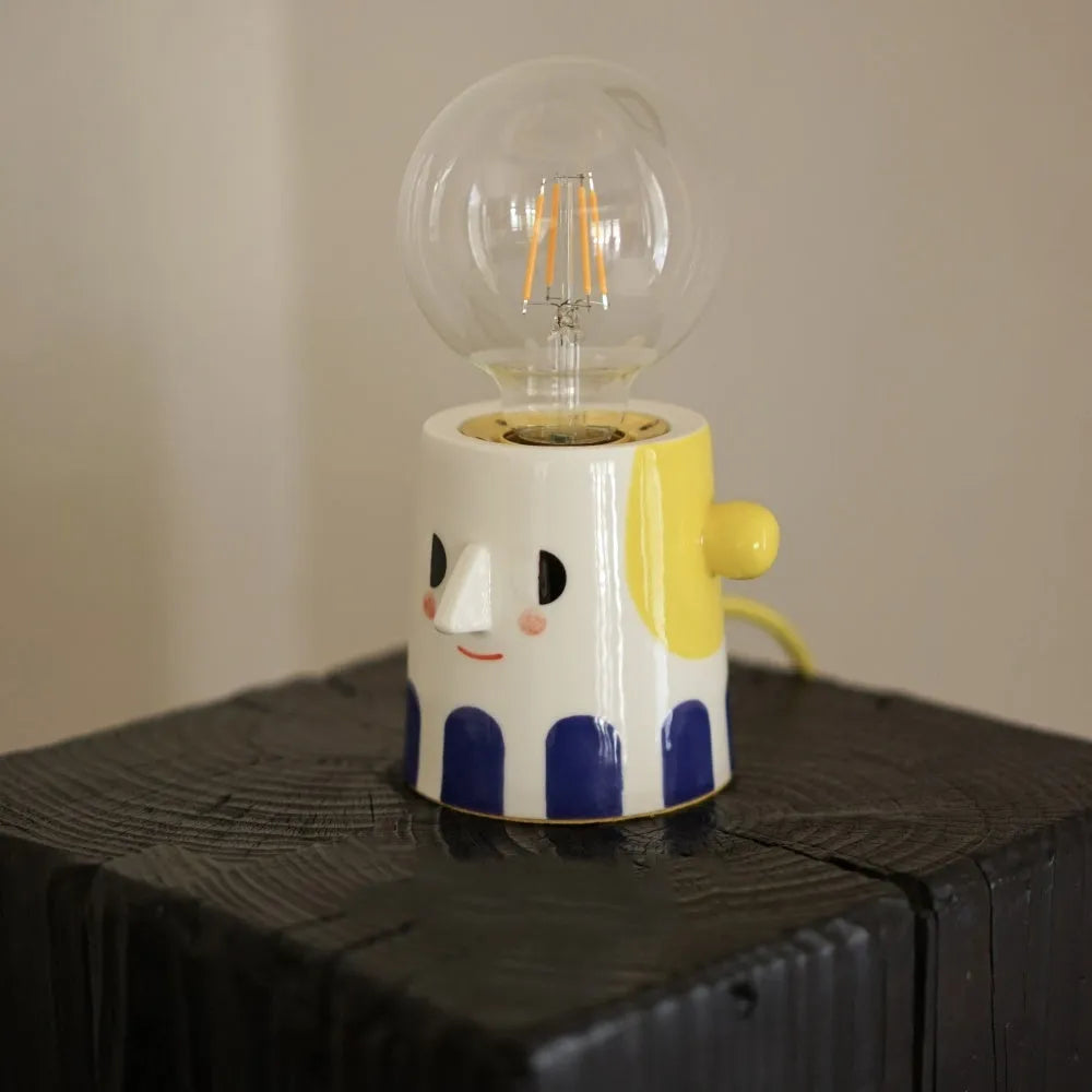 Handmade ceramic table lamp with ball headlight shade on wooden surface