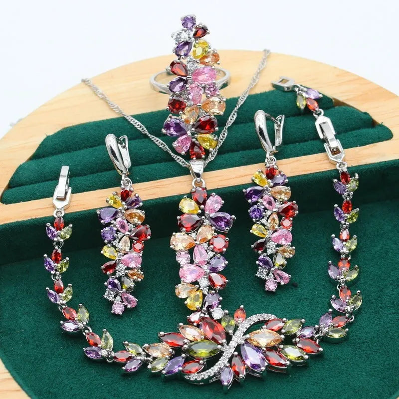 Retro-style jewellery set with necklace, bracelet, earrings, and ring featuring floral patterns in olive and purple colours.
